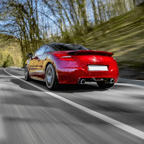 A red sports car driving through a autumn woodland area protected by a GPS tracker.