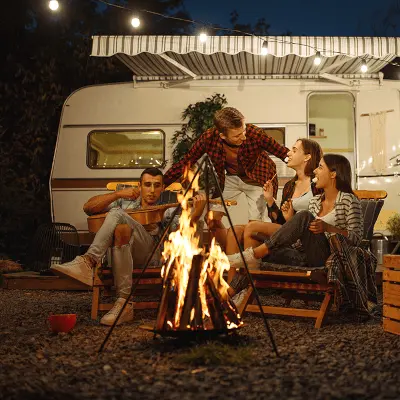 A happy group around a campfire outside their secure caravan enjoying peace of mind.